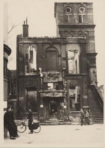 In het midden zien we het Wijnhuis, waar destijds het Stedelijk Museum was gevestigd, en rechts de Wijnhuistoren. Op 8 april verlieten de Duitsers de stad, maar enkele scherpschutters hadden zich in het Wijnhuis verschanst. De Canadezen schoten het Wijnhuis met vlammenwerpers in brand. Het gebouw brandde uit en er ging een groot deel van de collectie verloren.
